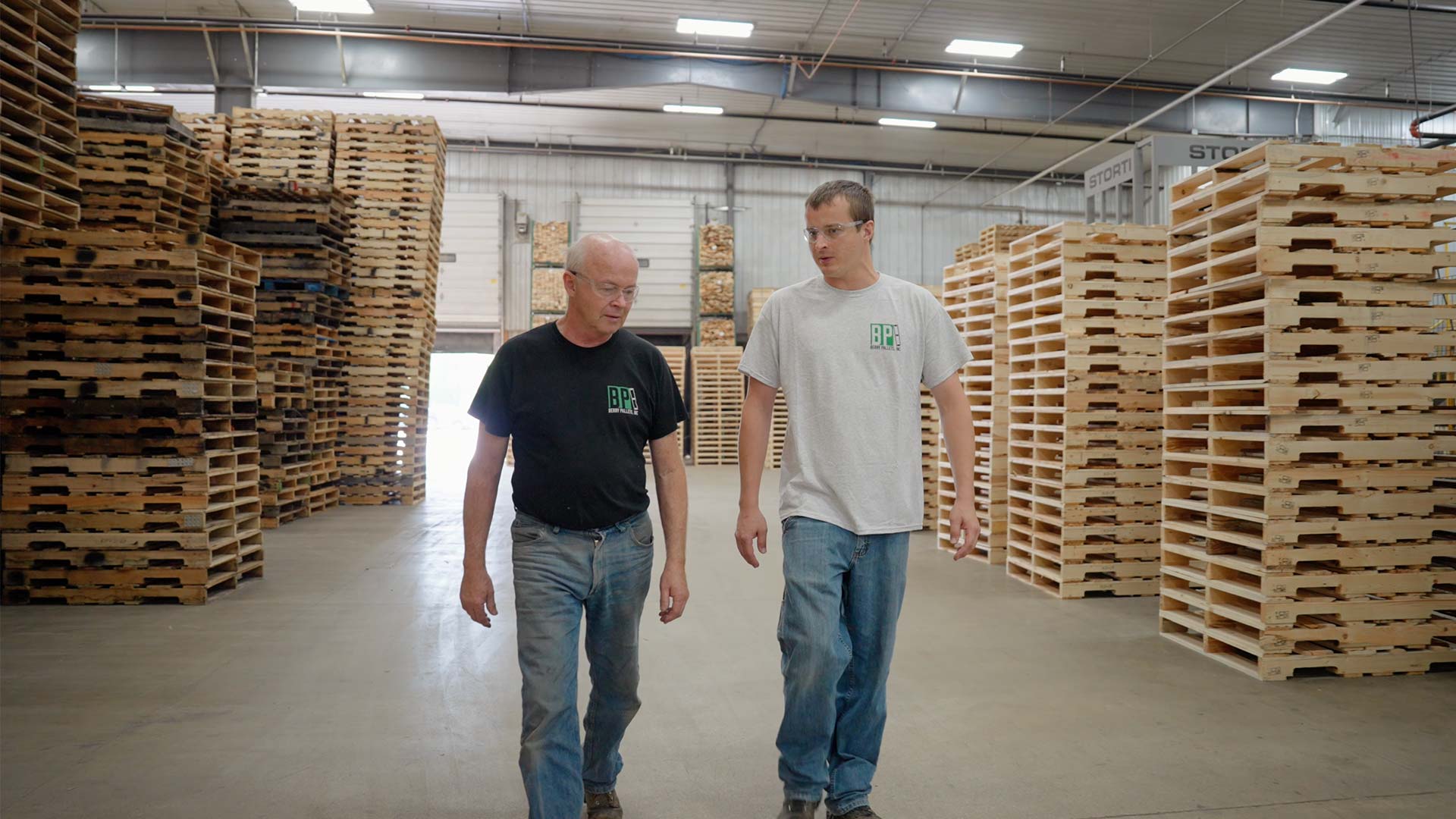 Berry Pallets Employees Conversing While Walking Through Berry Pallets
